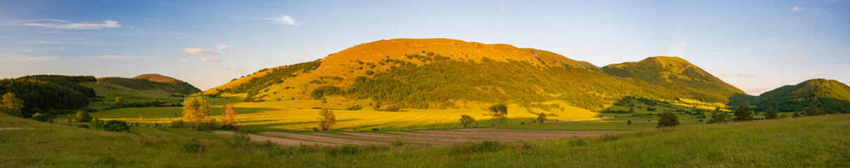 Fototapeta premium Sunset dramatic sky over Montelago highlands, Marche, Italy. Unique hill and mountain green landscape.