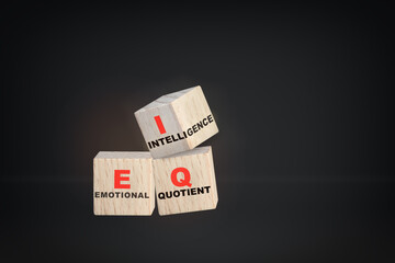 Emotional quotient and intelligence written on wooden cube on black background. EQ and IQ formula for success concept