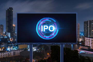 IPO icon hologram on road billboard over night panorama city view of Bangkok. The hub of initial...