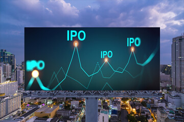 IPO icon hologram on road billboard over night panorama city view of Bangkok. The hub of initial...