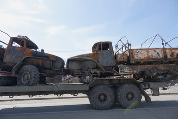 Liquidated Russian cars are transported for recycling. Damaged trucks go for recycling. Burnt military equipment.