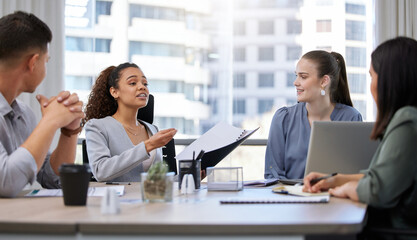 Shes got them hanging on her every word. Shot of a group of businesspeople having a meeting in an office at work.