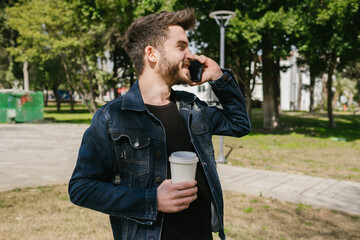 Voice calling, young man talking on the phone while holding coffee cup, have a good time