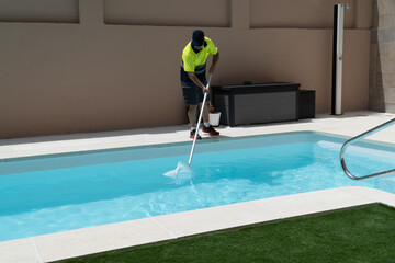 Operator cleaning a swimming pool with a butterfly trap - obrazy, fototapety, plakaty