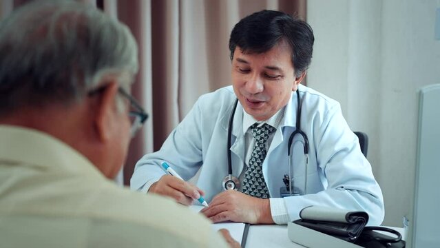 Senior elder grandfather patient talking to caring male doctor physician caregiver at nursing home in hospital, Doctor explaining well-being get support and medicare services at medical checkup visit.