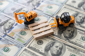 Toy construction equipment builds a new highway out of dollar bills.