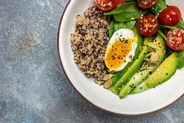 Keto diet plate quinoa, avocado, egg, tomatoes, spinach and sunflower seeds on light background. Healthy food, ketogenic diet, diet lunch concept, place for text, top view