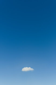 Blue sky with single small cloud