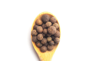 Spice Allspice in wooden spoon vertically on white background. Flat lay. Indian cuisine concept