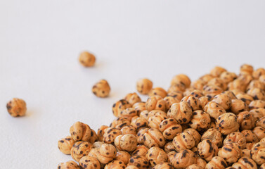 Roasted spicy chickpeas, yellow chickpeas on white background.