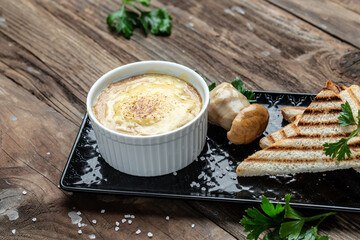 Julienne with mushrooms in creamy sauce, julienne. Bechamel sauce and cheese baked in glass Mini Baking cup with grilled toasts. Restaurant menu, dieting, cookbook recipe