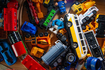 Children's plastic toys. Transport, construction vehicles, robot, floor. Top view. Selective focus