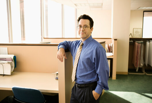 Businessman standing by office cubicle