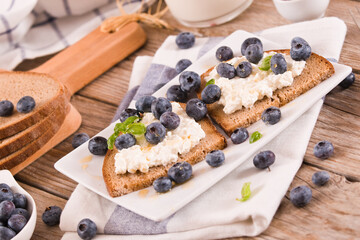 Rye bread with cottage cheese, blueberries and honey.