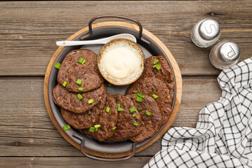 chicken liver bowls on a metal plate on a wooden background.
