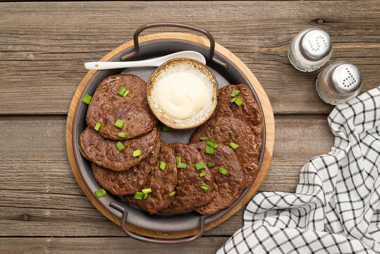 chicken liver bowls on a metal plate on a wooden background.