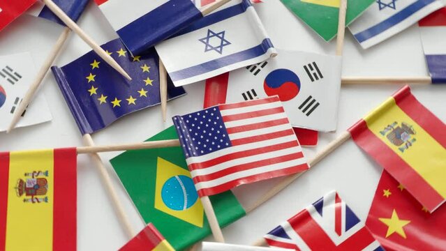 Top view of rotating paper wooden  sticks with paper  flags of different countries, video 4k resolution