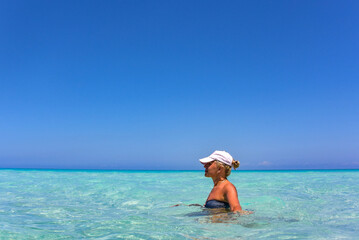 Fototapeta na wymiar Beautiful Sunny day on the coast of Cuba, Varadero, a Cuban girl swims in the azure waters of the Atlantic ocean.