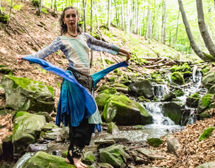 woman dancing near a stream