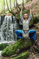 woman sitting near a waterfall..