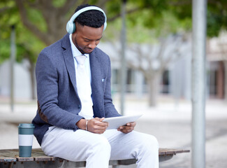 No masterpiece was ever created by a lazy artist. Shot of a young businessman using a tablet outside in the city.