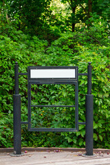 An empty billboard with a place to copy in a natural green park.