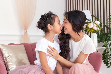 Daughter and mother. Asian appearance. The family is happy. Smiles and laughter. They look at each other.