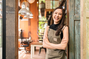 portrait of asian adult female woman wear apron standing at entrance of her workshop pottery studio incasual cloth relax smiling confident and warm welcome,asian woman with her home studio workshop - Powered by Adobe