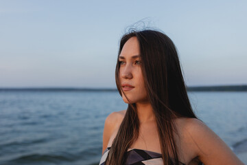 Fototapeta na wymiar portrait of beautiful brunette woman on blue sea background