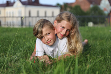 Caucasian brother with sister in the park on the grass