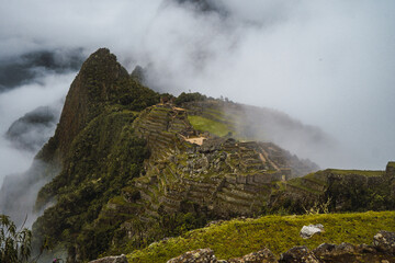 Wide angle view of Machu Picchu inca city in a cloudy day.