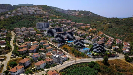 Resort view from a helicopter.Clip. A beautiful resort area with hotels, green parks, views of sports fields and large green mountains in the background