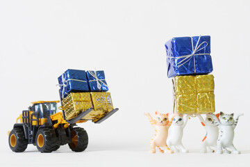 Cute toy kittens and a forklift along with yellow and blue gift boxes. The concept of collecting...