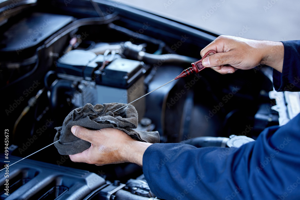 Poster checking your oil. high angle shot of an unrecognizable male mechanic working on the engine of a car