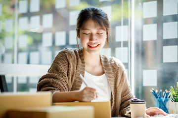 Startup small business entrepreneur SME or freelance Young Asian woman using a laptop computer with...