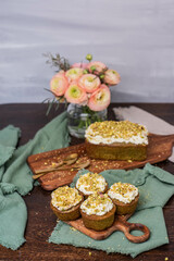 Pistazienkuchen und Cupcakes mit Frosting, Kaffeetisch Frühling mit Kuchen und Blumenstrauß