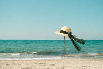 Sun hat with ribbon on the beach - obrazy, fototapety, plakaty