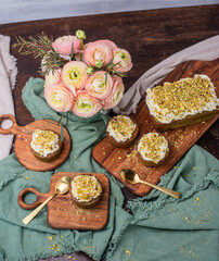 Pistazienkuchen und Cupcakes mit Frosting, Kaffeetisch Frühling mit Kuchen und Blumenstrauß