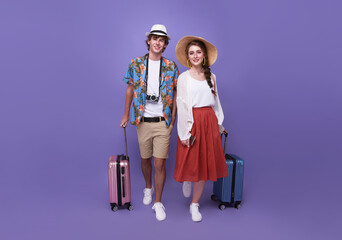 Happy couple tourist with baggage going to travel on holidays isolated on purple background....