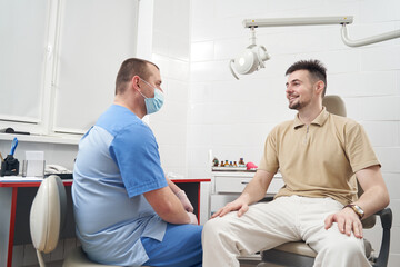 Obraz premium Cheerful man during consultation with doctor in clinic