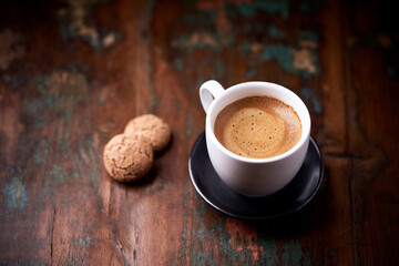 Cup of coffee with Amaretti (Italian biscuits) on rustic wooden background. Copy space.	