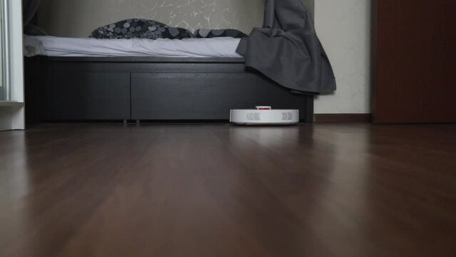 robot vacuum cleaner vacuums a room in the house, modern automatic cleaning, cleanliness in the bedroom