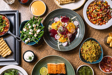 Assorted food set on table, Salmon with broccoli, salad, club sandwich, salad with quinoa, tartar from beef
