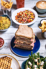 Assorted food set on table, Salmon with broccoli, salad, club sandwich, salad with quinoa, tartar from beef
