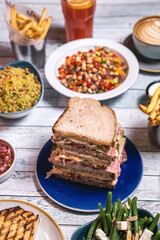 Assorted food set on table, Salmon with broccoli, salad, club sandwich, salad with quinoa, tartar from beef