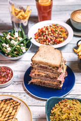 Assorted food set on table, Salmon with broccoli, salad, club sandwich, salad with quinoa, tartar from beef