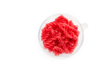 Close-up background of Fusille and Rotini in a glass bowl on white. pasta colorata