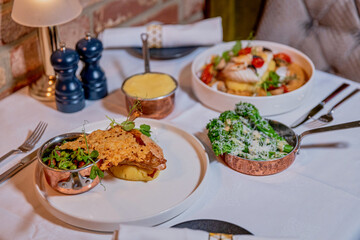 Assorted view of dinner table with delicious food set  for two, seafood,Salmon with broccoli, salad, club sandwich, salad with quinoa, tartar from beef