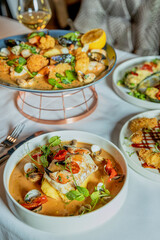 Assorted view of dinner table with delicious food set  for two, seafood,Salmon with broccoli, salad, club sandwich, salad with quinoa, tartar from beef