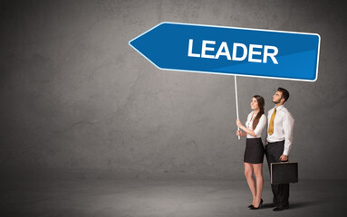 Obraz premium Young business person in casual holding road sign